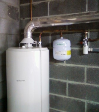 Accumulateur gaz Ariston avec vase expansion sanitaire installé dans un sous-sol.